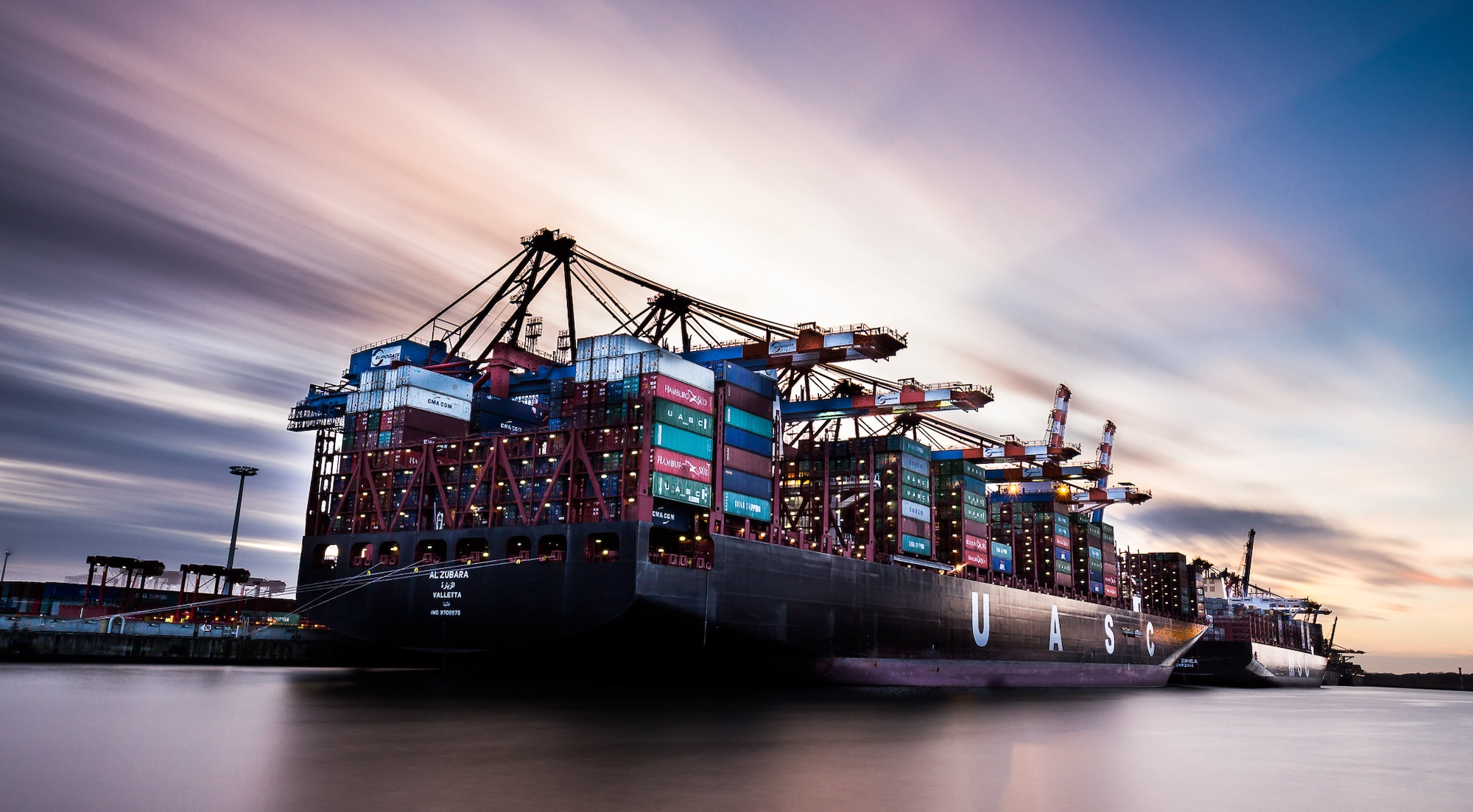 Container vessel alongside port cranes